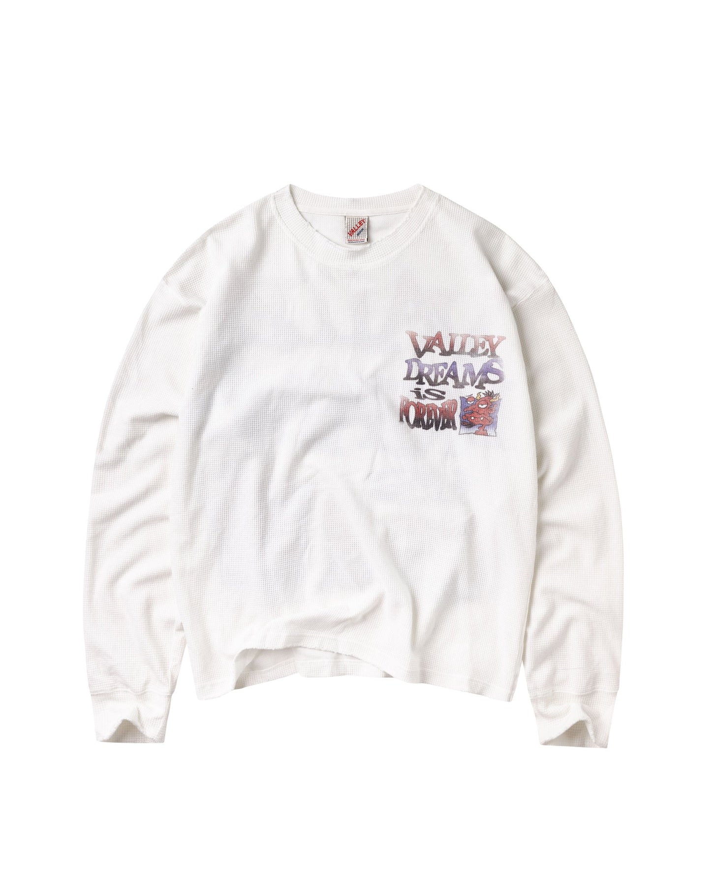 A white long-sleeve t-shirt with a colorful graphic on the left chest that reads 'VALLEY DREAMS IS FOREVER' in a graffiti-style font, displayed flat against a white background.